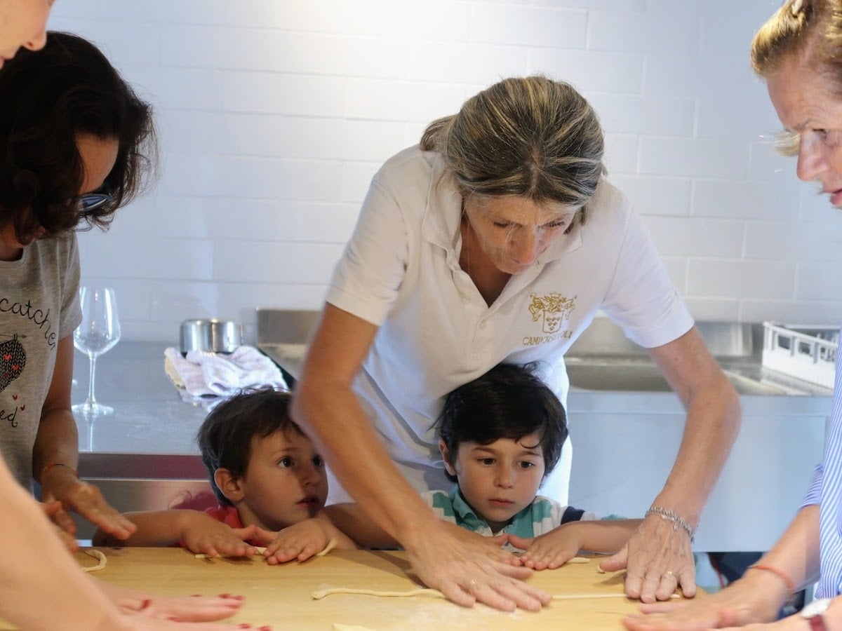 family learning how to make vegan Italian food during a cooking class at Camporsevoli in Tuscany 