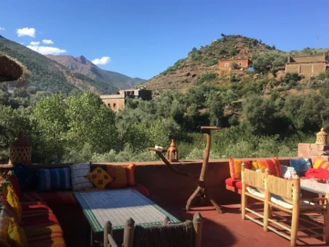 rooftop with tables and couches backed by mountains