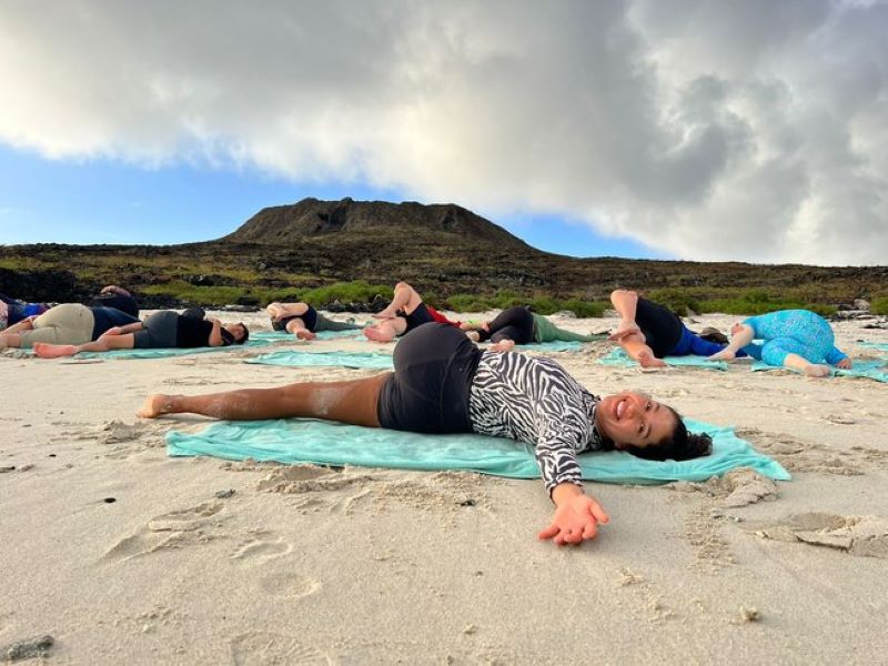 participants doing yoga on a sandy beach