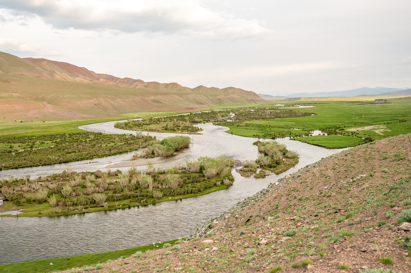 river running through verdant green fields