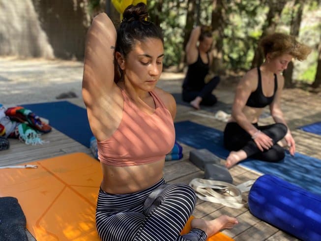 women sitting on yoga mats on an outdoor yoga deck on a Mallorca yoga retreat in Sóller