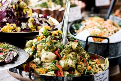 A vibrant assortment of vegan dishes including roasted fennel, mixed salads, and fresh vegetables