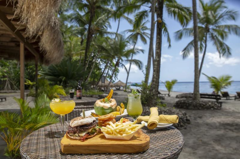 travelers enjoying a vegan meal and tropical drinks at the plant-based Anse Chastanet Resort in St. Lucia