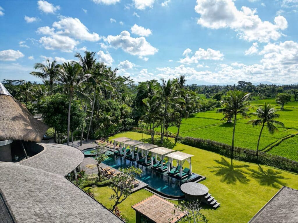 pool, palm trees, and grounds of the vegan Bali hotel Gdas Bali Health & Wellness Resort in Ubud