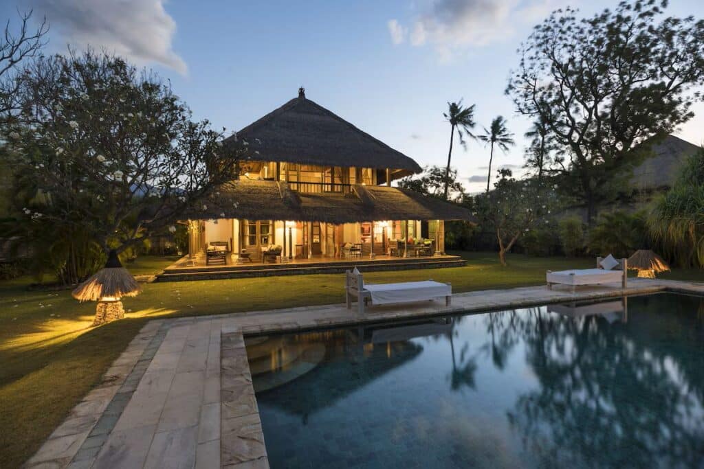 pool surrounded by day beds in front of a villa at the vegan-friendly Puri Ganesha Villas in Pemuteran, Bali