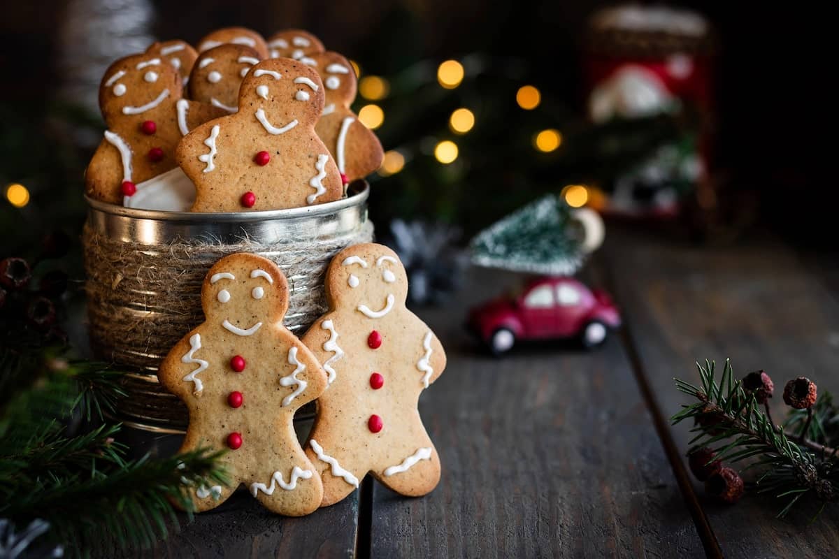 tin of homemade gingerbread cookies with a Christmas tree in the background