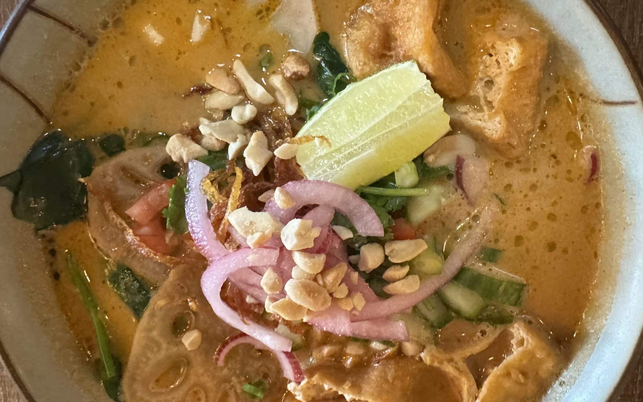 A bowl of noodles full of vegetables including lotus root and tofu in a peanut broth served at the Do Chay vegan restaurant in Vancouver