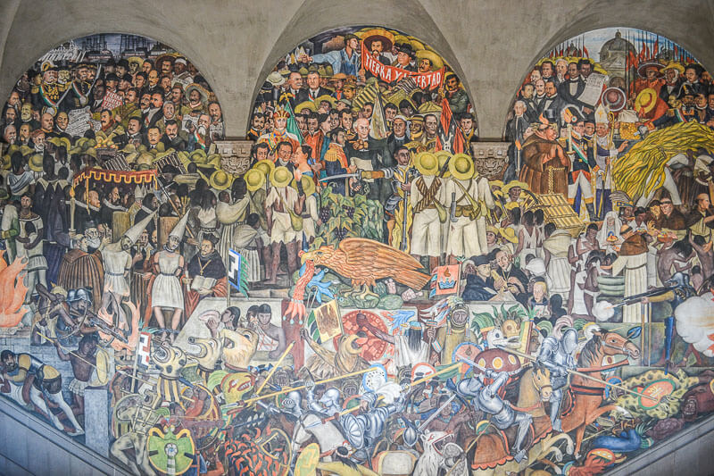 person viewing the History of Mexico Mural by Diego Rivera while exploring the Mexico City art scene