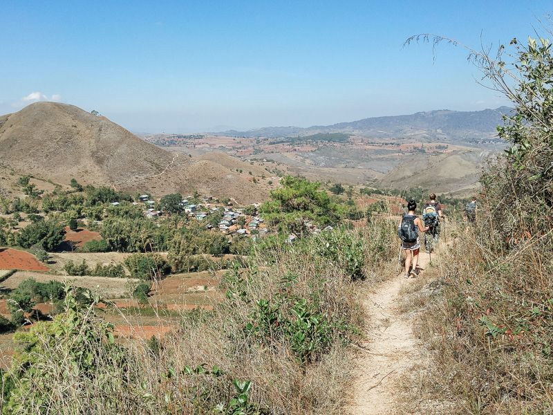 group to people hiking through rolling hills on the way from Kalaw to Inle Lake in Myanmar