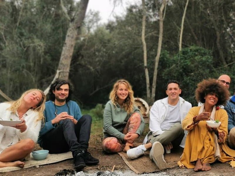 group of people sitting on yoga mats in the forest on a Mallorca wellness retreat