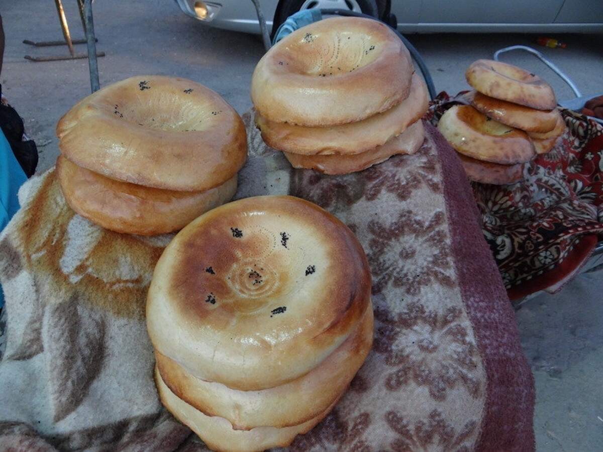 Stacks of freshly baked non bread on display at a market in Samarkand, Uzbekistan. This traditional Uzbek bread is a popular vegetarian option and a staple in local cuisine.
