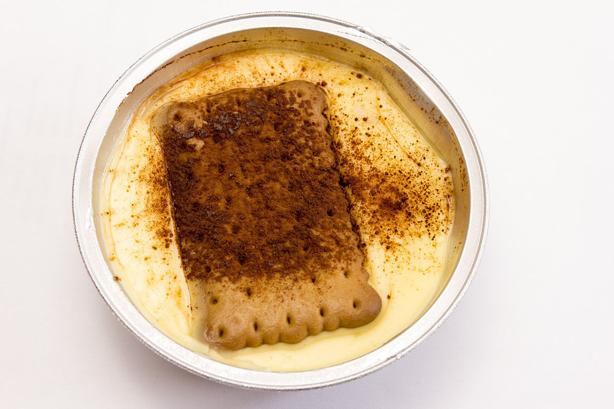 Natillas, a traditional Spanish dessert featuring creamy vanilla custard topped with a cinnamon-dusted biscuit.