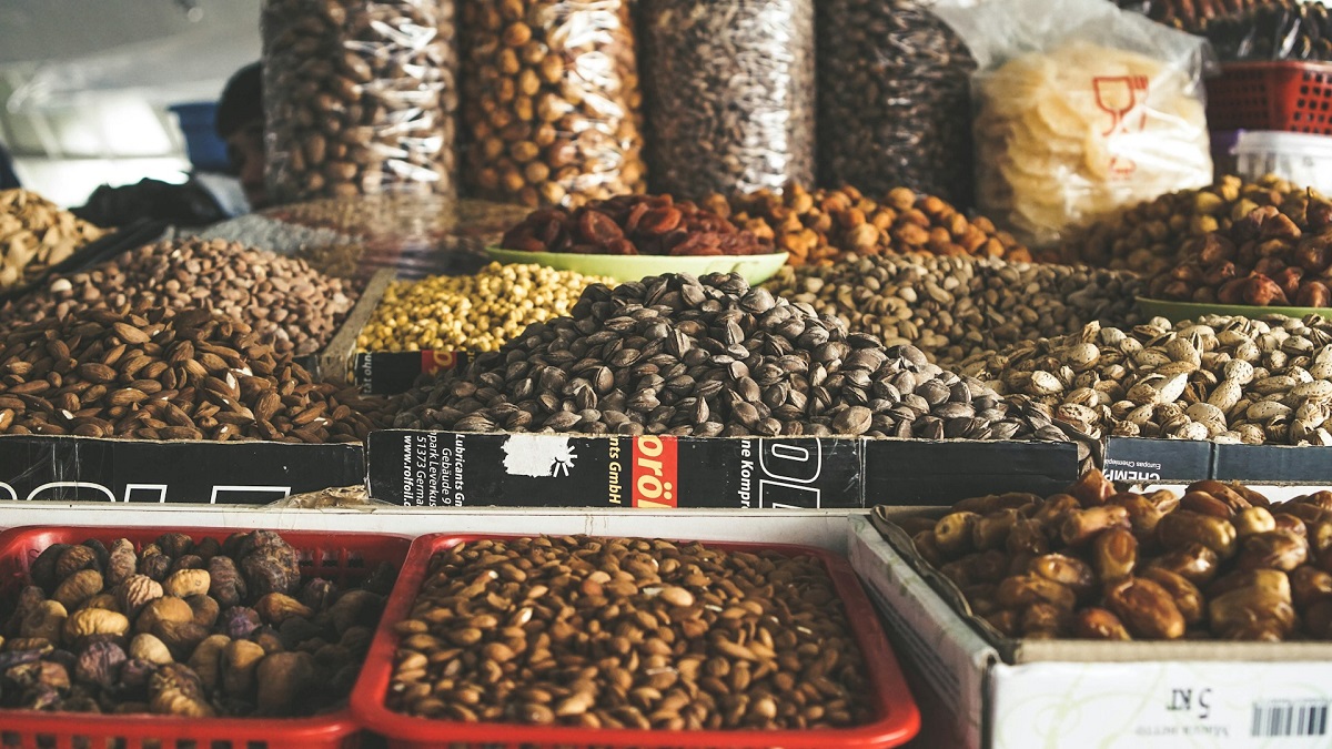 A variety of dried fruits and nuts on display at Toshkent Marketplace in Uzbekistan. The selection includes almonds, pistachios, figs, and more, showcasing the rich array of vegetarian-friendly snacks and ingredients available.