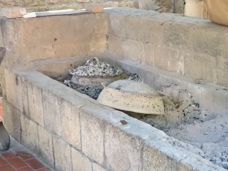Two Peka ovens in an outdoor hearth.