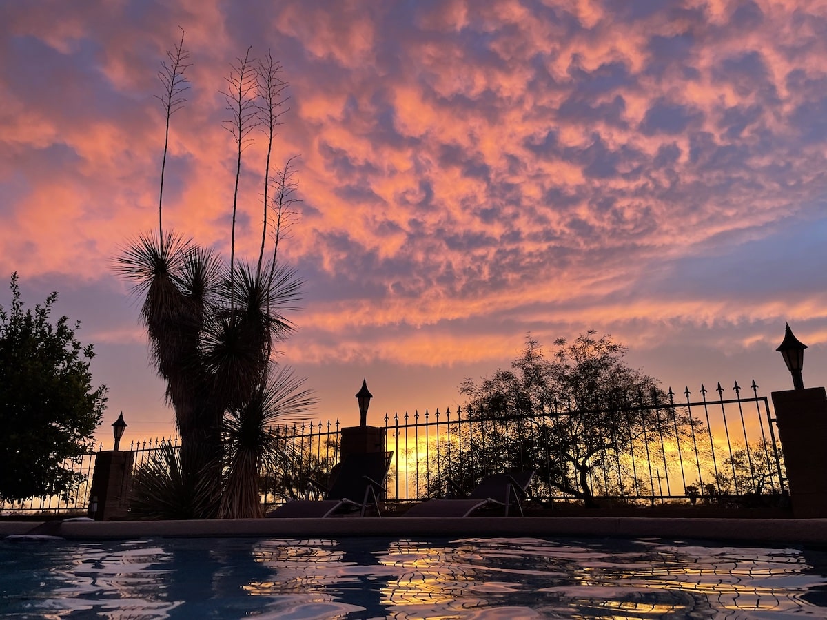pool at the vegan B&B Rancho Vegano at sunset with the sky lit up in yellow, orange, and pink