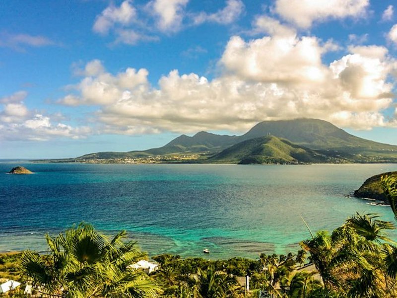 turquoise waters with a volcano in the background as seen from Nevis