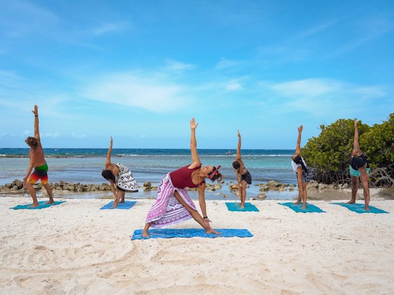 group of people doing yoga on the beach during a silent retreat in Aruba 