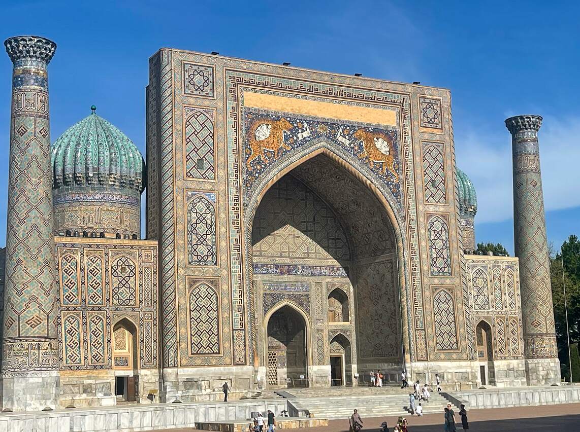 The stunning Sher-Dor Madrasah monument in Samarkand, Uzbekistan, featuring intricate tile work and architectural details under a clear blue sky. This historic site is a prominent example of Islamic architecture in Central Asia.