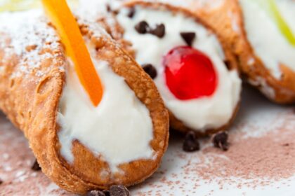 a plate of 3 Sicilian cannolis in different flavor variations