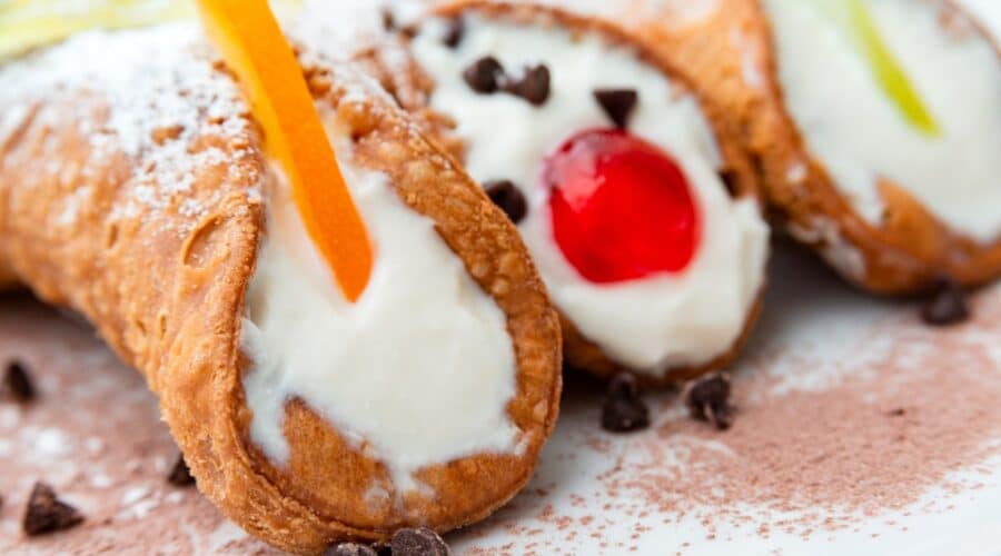 a plate of 3 Sicilian cannolis in different flavor variations