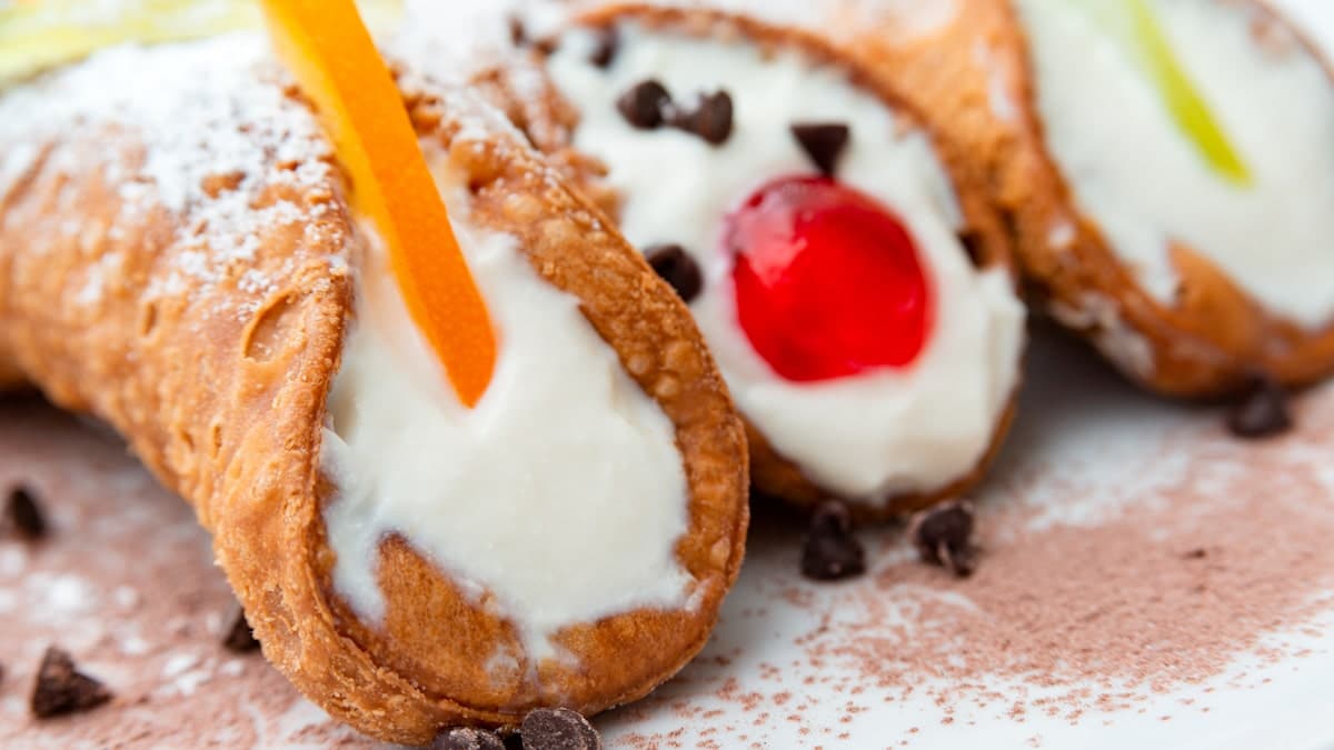 a plate of 3 Sicilian cannolis in different flavor variations