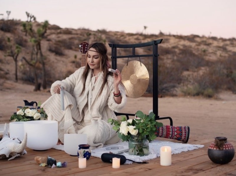 woman leading a spiritual yoga retreat in Joshua Tree while surrounded by candels and crystals