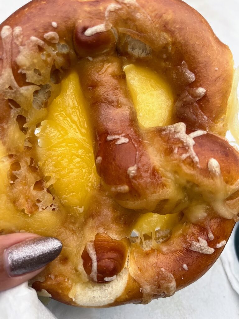 Bretzel with cheese melted onto it from a food stall in Strasbourg