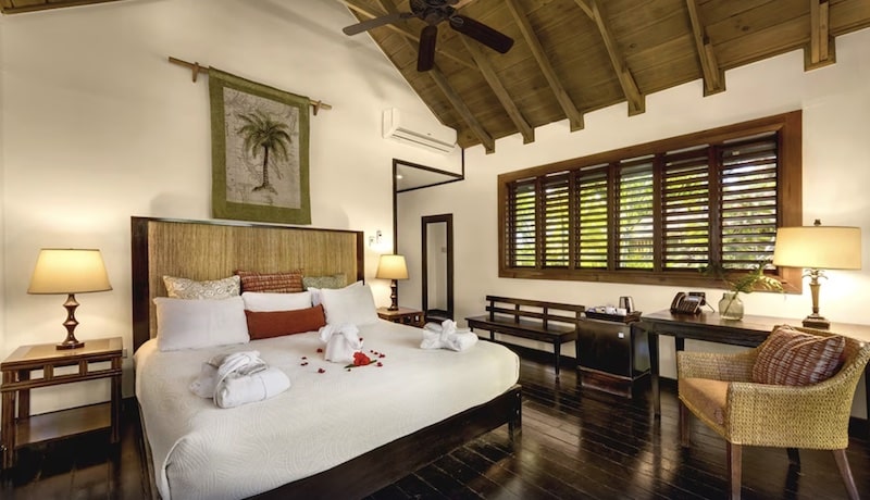 resort guest room with flower petals and towel animals on the bed