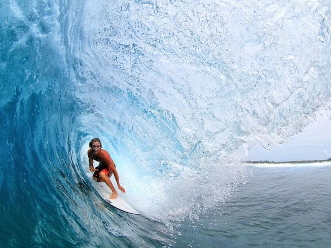 man catching a giant wave during a surf and yoga retreat in Bali
