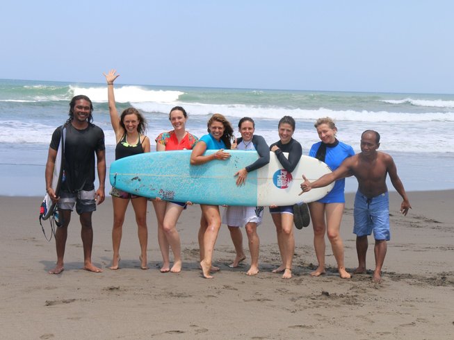 people on a surf and yoga retreat in Bali holing a surf board
