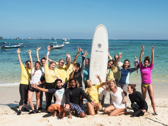 group of people posing on the beach during a yoga and surf retreat in Bali