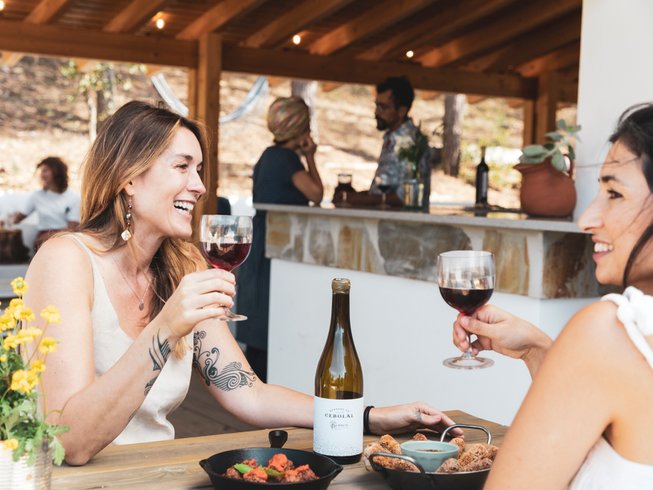 two women laughing and drinking red wine