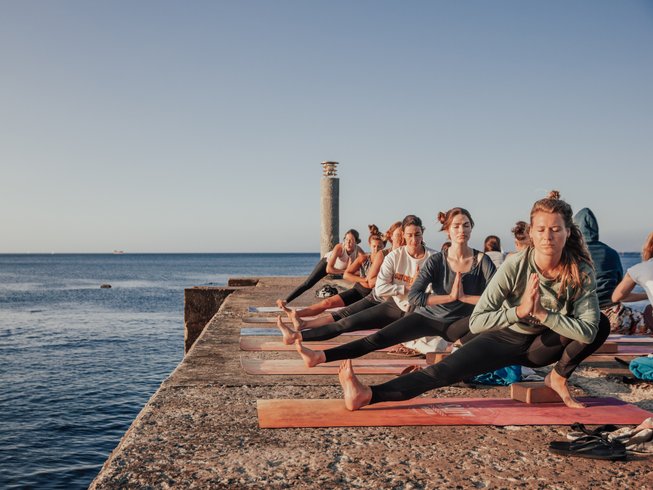 group of women doing outdoor yoga on a yoga and surf retreat in Portugal