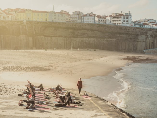 group of people doing yoga on the beach during a retreat in Portugal