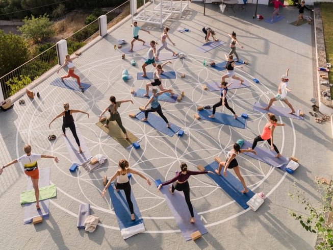 people on a Mallorca yoga retreat standing a circle while doing their asanas