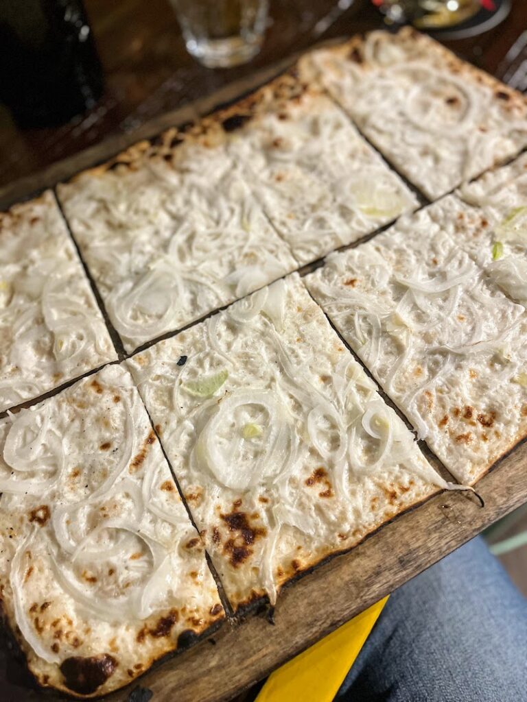traveler eating Tarte Flambee or Alsatian Pizza in Strasbourg, France