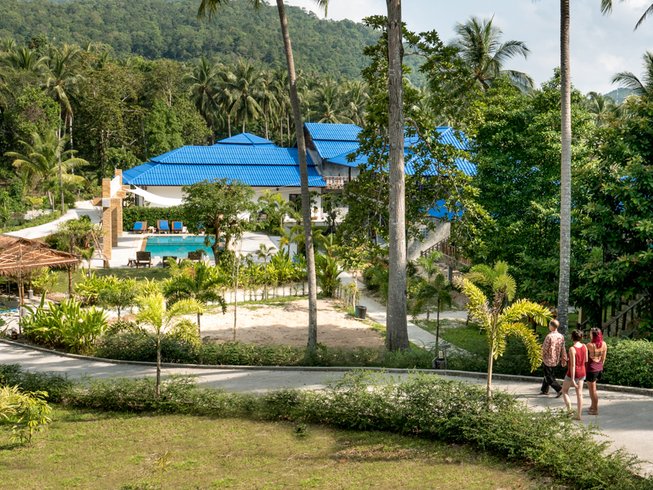 People walk down a paved path at one of the top vegan yoga retreats in Thailand
