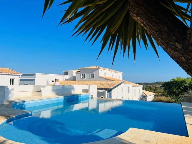 white buildings behind a pool with bright blue water in Portugal