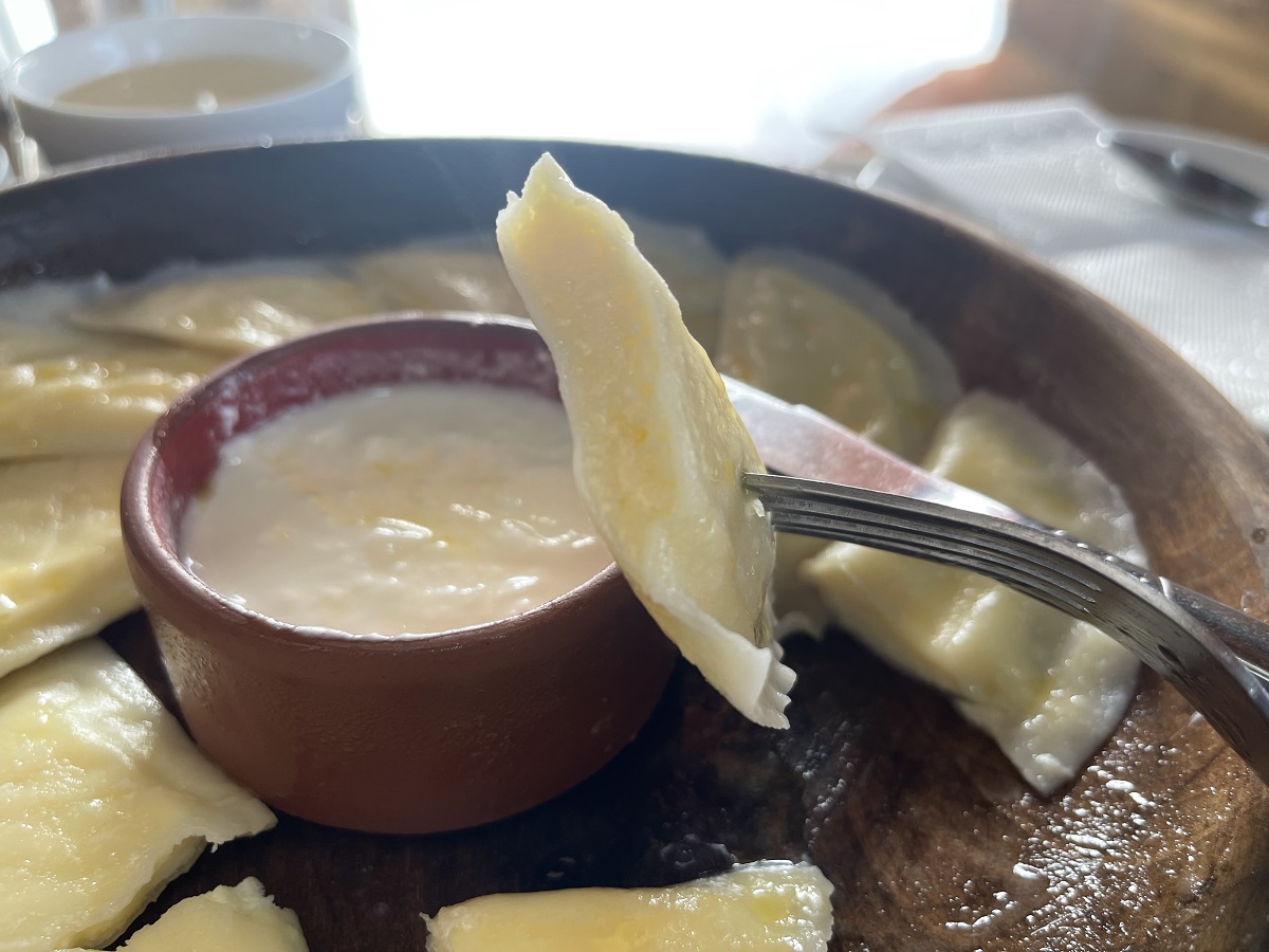 A close-up of tukhum barak, a traditional Uzbek dumpling dish, served with a creamy dipping sauce at Terrassa Cafe in Khiva, Uzbekistan. A delightful vegetarian option in Uzbek cuisine.