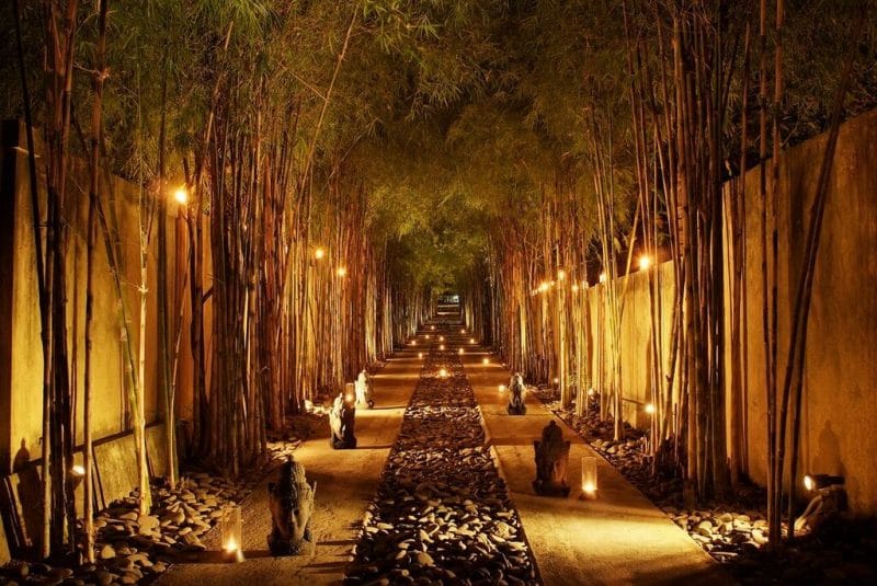 walkway lined with meditation stones and candles at night