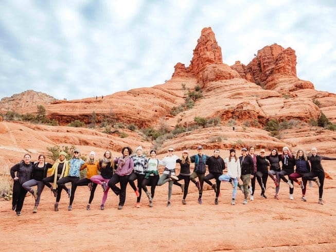 people standing in a line in tree pose during a spiritual retreat in Sedona, Arizona