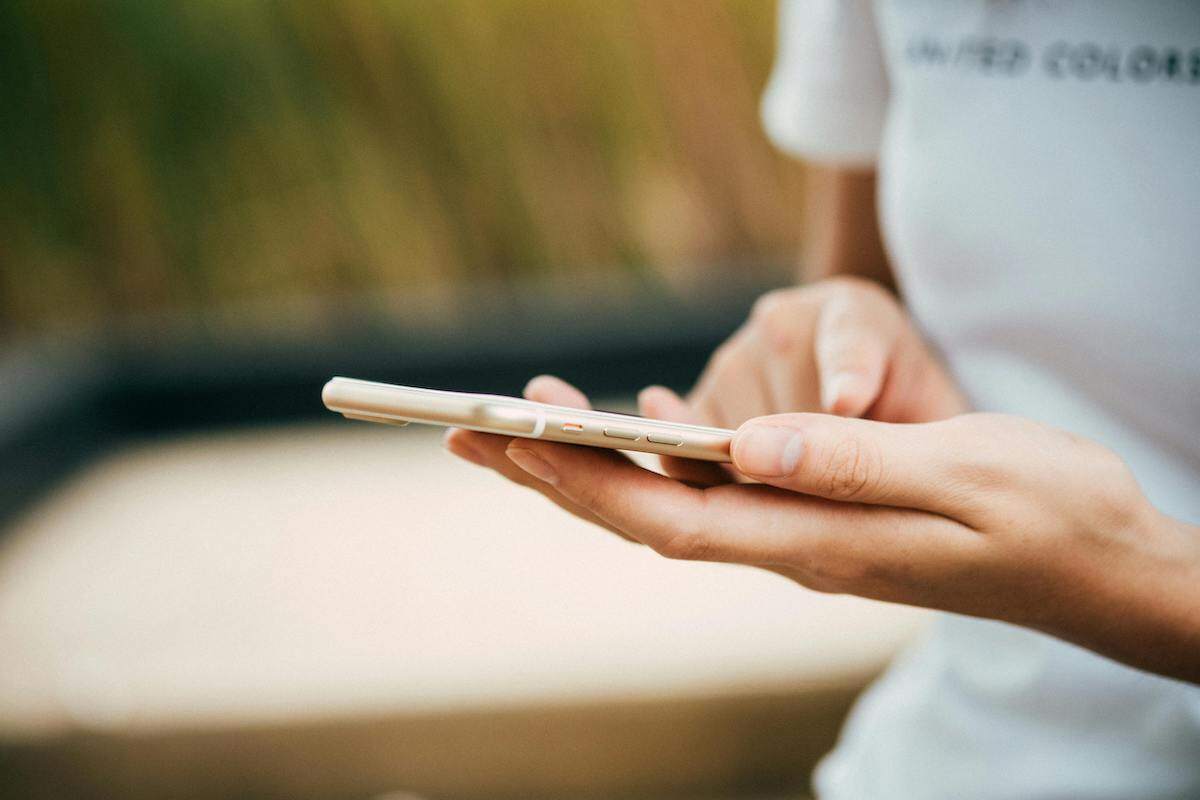 A woman scrolling on her smartphone, using apps like Happy Cow and Google Translate, which can make it easier to find and enjoy vegetarian dishes in Uzbekistan.