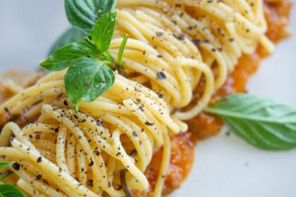 vegan pasta dish in Italy topped with black pepper and basil on a white plate
