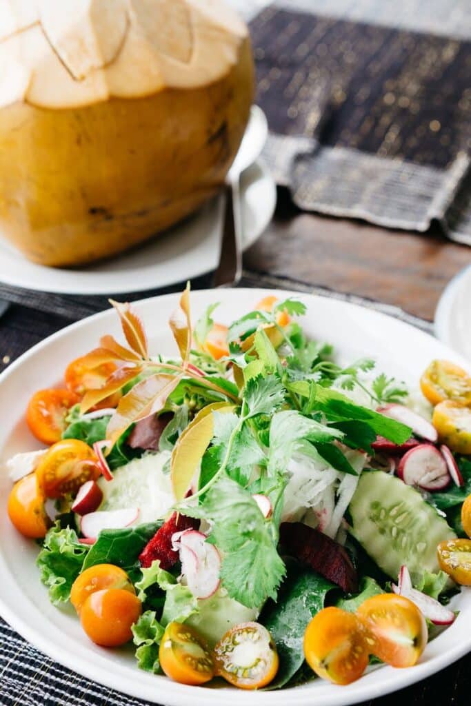 plate of salad with a coconut on the side