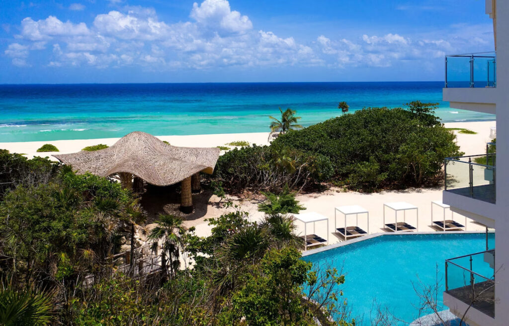 pool and beach in front of the Palmaïa House of AïA vegan resort in Mexico