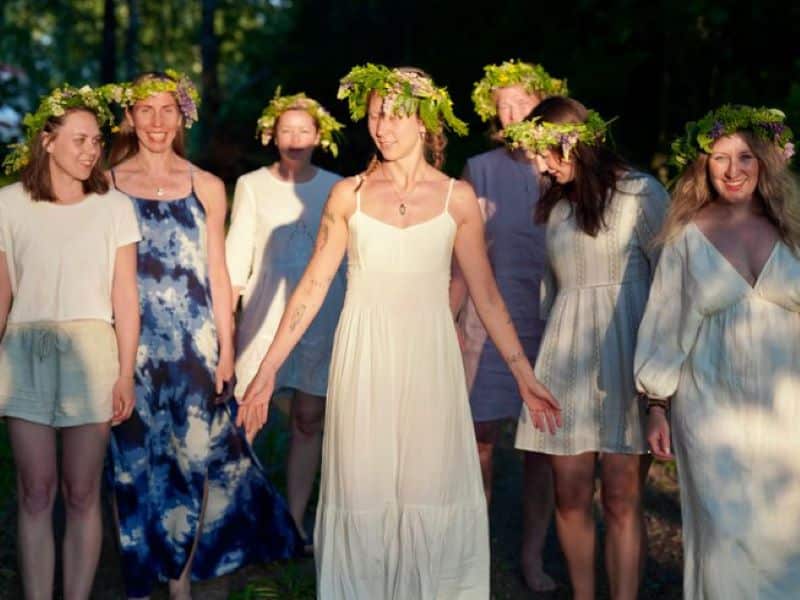 women holding hands wearing flower crowns