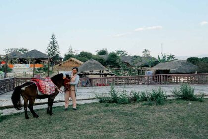 A woman grooming her pony in Pai.