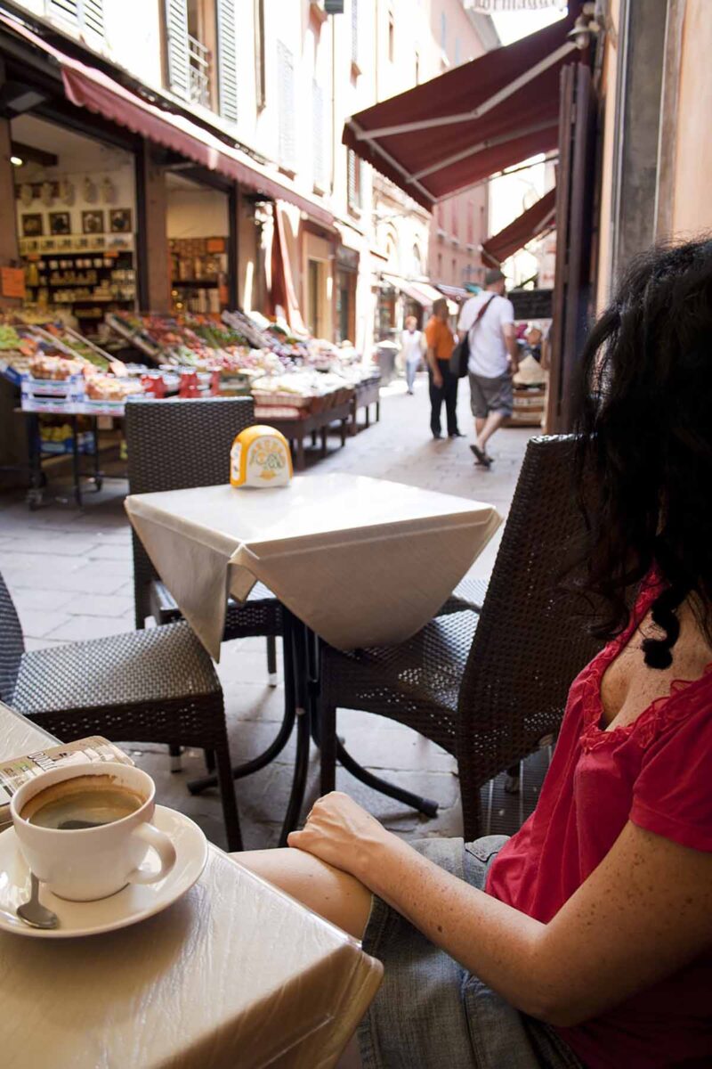 A woman enjoying a coffee in a restaurant in Bologna.