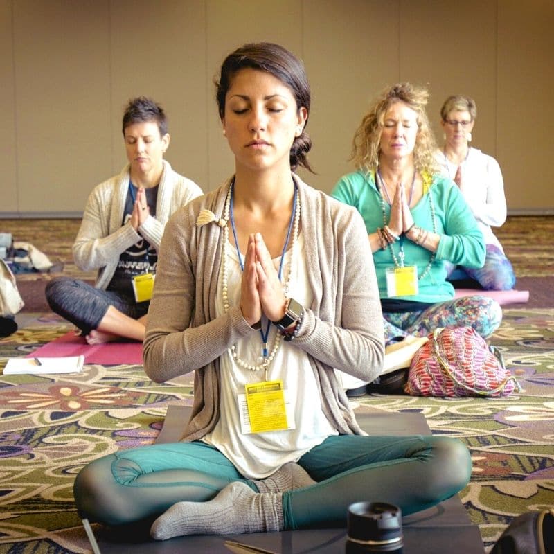 Woman meditating in a group on a retreat in mexico