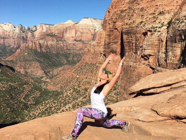 woman doing yoga on top of a mountain
